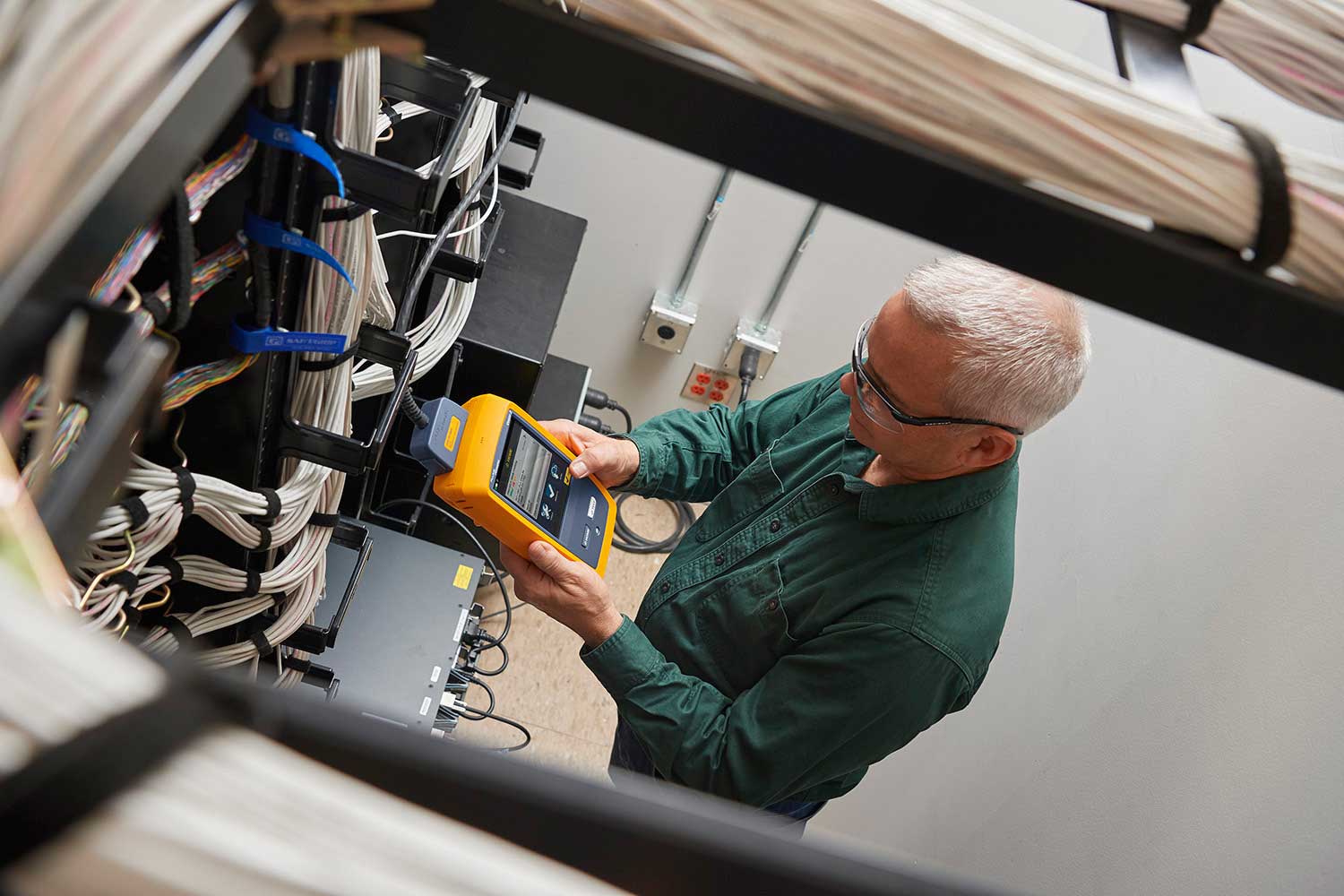 Man testing network cabling in a small room