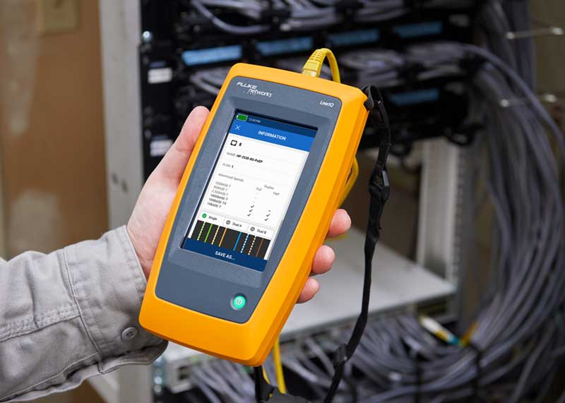 Un técnico sostiene un comprobador de cables y de red LinkIQ de Fluke Networks Un técnico sostiene un comprobador de cables y de red LinkIQ de Fluke Networks