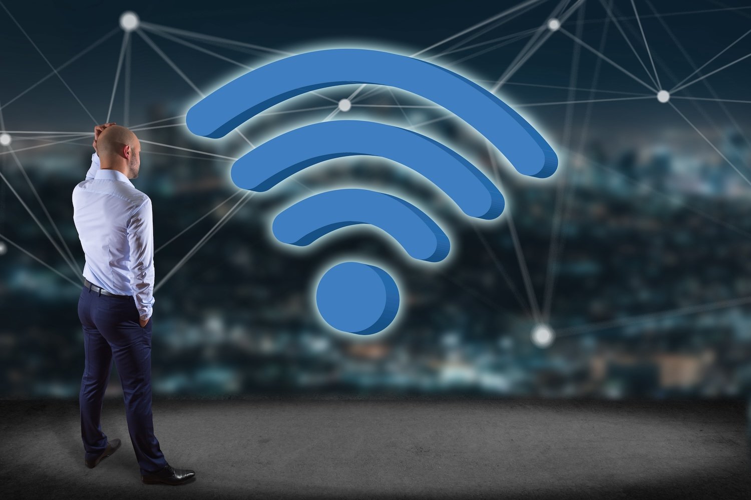 一位男士站在一个巨大的 Wi-Fi 图标前，背景是夜间城市景观