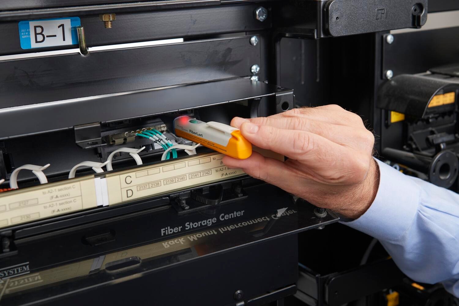 Image of Fluke Networks FiberLert™ Live Fiber Detector being used to check a transceiver.